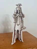 Full front view of ceramic judge sculpture on wood surface