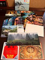 Group of postcard booklets, loose postcards and unidentified calendars displayed on table