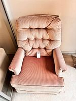 Front view showing button-tufted back, seat, arms, upholstery