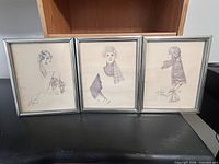 All three framed prints side by side on tabletop