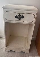 Front view showing table, drawer, metal pull, open shelf