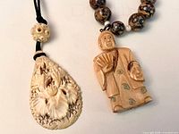 Both necklaces side by side showing pendant designs and cords/beads