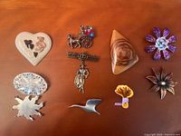 Group shot showing all ten brooches and pins