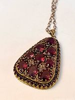 Front view of pendant showing arrangement of large and small purple stones