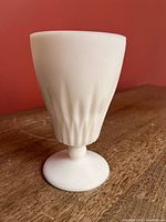 Side view showing fluted body and footed base