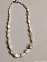 Full view of necklace laid flat showing bead arrangement and clasp