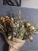 Wrapped bundle of assorted dried stems with roses, foliage and gold glitter balls