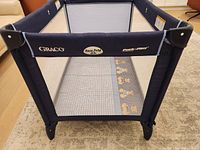 Front view showing Graco logo, Easy Fold badge, mesh side and mattress graphics