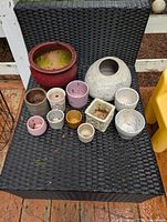 All planters arranged on black wicker chair