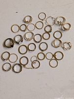 Top-down view of entire lot showing quantity and variety of gold-tone rings