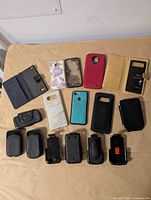 Overview showing eight cases, six belt clip holsters and leather pouch