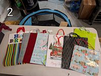 Eight gift bags laid flat to show all designs