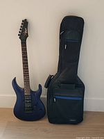 Full view of Cort purple guitar beside gig bag