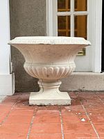 Front view of concrete urn planter showing overall shape and pedestal base