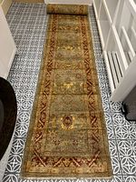 Full length of runner rug on floor showing overall design