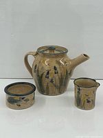 Front view of Forks Road Pottery teapot, sugar bowl and creamer showing size, shape and floral design