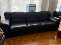 Full front view of black leather 3-seat sofa