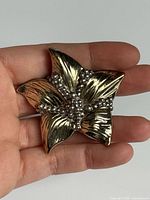 Front view of sterling silver floral brooch showing design and patina