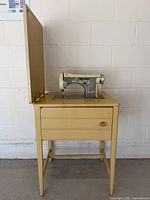 Full view of sewing machine mounted in cabinet