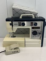 Front view of Brother VX760 sewing machine with foot pedal and cover displayed