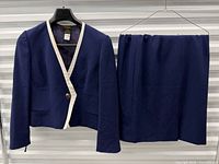 Front view of jacket and skirt on hangers