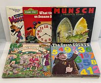 Front view of five vintage children’s LP records: Mousercise, Sesame Street clock cover, Munsch Favourite Stories, Mainly Mother Goose, The Count Counts