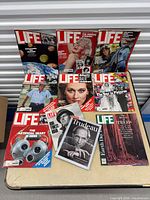 Group shot of nine Life magazines arranged on table