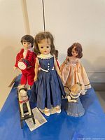 Group shot of four dolls, angel figurine and rocking horse