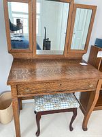 Front view of oak vanity with tri-fold mirror and stool