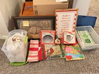 Overall view of all items on floor including boxed Duralex pieces, linens, framed art, bins