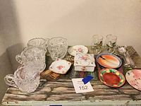 Lot overview showing cut glass, porcelain dishes, tumblers and flatware