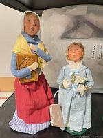 Adult female and young girl caroler figurines with tags