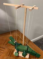 Green wooden crocodile string puppet mobile on its stand