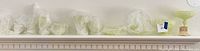 Entire lineup of pale yellow custard glass pieces wrapped on mantle