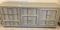 Front view of gray 3-door sideboard showing geometric panel design