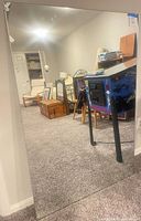 full view of large frameless mirror leaning against wall