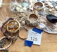 Overview of assorted bangles, bead bracelets, faux pearls, charms in bags