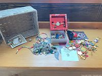Overall view of lot on shelf showing earrings, necklace, bracelets, pins, watch boxes