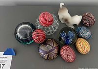 Group shot showing all painted eggs and glass paperweights
