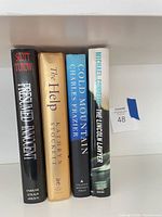 Front spines of all four hardcover books aligned on shelf