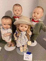 Front view of all four dolls on stands