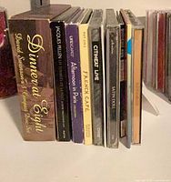 Row of CDs showing spines, titles visible: Dinner at Eight, Jacques Fellen, Afternoon in Paris, French Café, Citiheat Live, Satin Soul and others