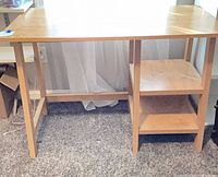 Front view of desk showing legs, open shelving and finish