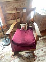 Vintage wooden rocking chair with burgundy cushion front view