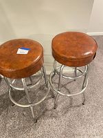 Both bar stools showing brown seats and chrome frames
