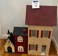 All three wooden houses grouped together showing relative sizes