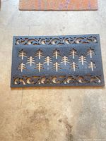 Black rubber mat with evergreen tree cutouts
