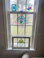 Group shot of all four stained glass pieces displayed in window