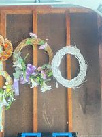Two wreaths, one floral grapevine, one white plain