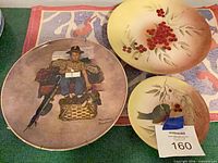 Group of four plates showing Rockwell scene and three berry designs